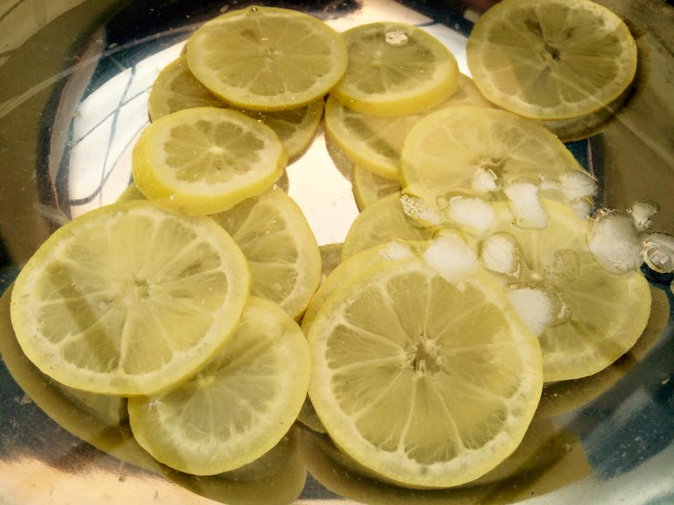 Lemons and limes with peeler sitting in bowl of a bar for